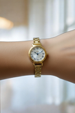 ساعت مچی زنانه الگانس با بند فلزی ظریف رنگ طلایی و نشانگرهای عدد رومی